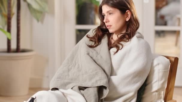 Uma Jovem Morena Senta Uma Cadeira Embrulhada Cobertor Pensa Algo — Vídeo de Stock