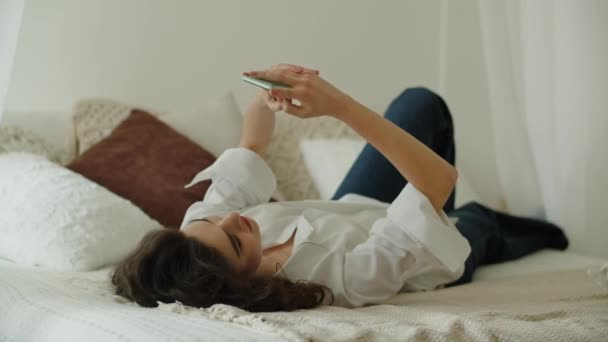 Okouzlující Dívka Usmívá Zatímco Píše Někým Ložnici Žena Používající Smartphone — Stock video