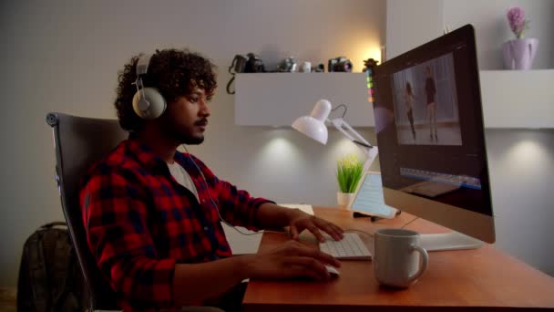 Een Jongeman Met Een Koptelefoon Bewerkt Video Videograaf Werkt Vanuit — Stockvideo