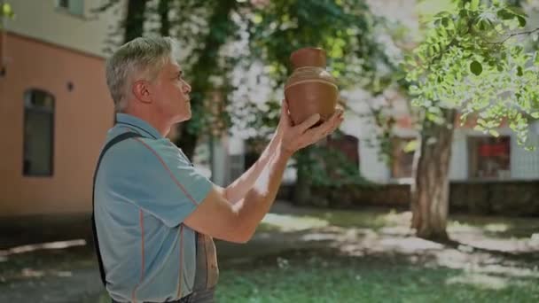Een Oude Man Professionele Pottenbakker Houdt Keramische Pot Buiten Zijn — Stockvideo