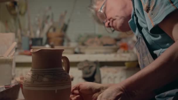 波特修好了陶土罐的颈部 在材料上加了些水 专业工匠装饰陶瓷手工制作的碗 陶瓷作坊的男性雕塑家 养恤金领取者浓缩成型壶 — 图库视频影像