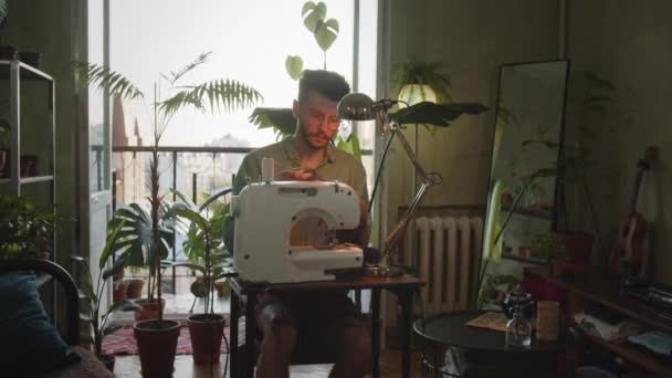Άντρας Σχεδιαστής Ρούχων Εργάζεται Στη Ραπτομηχανή Από Σπίτι Νέος Επιχειρηματίας — Αρχείο Βίντεο