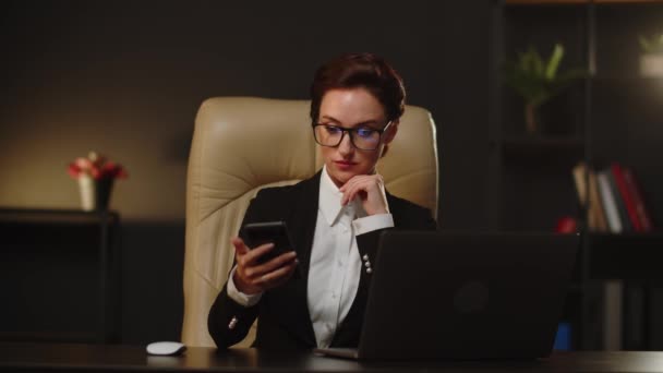 若いビジネス女性は スマートフォンサーフィンを使用するための自由な時間を持っています 勤務時間中に恋人とチャットする笑顔のビジネス女性 マネージャーの女性は働いていたときに匿名からフラットメッセージを受け取りました — ストック動画
