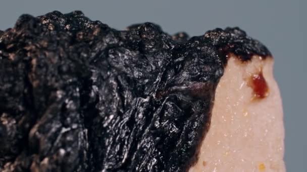 在火焰的影响下 一片被灰色背景隔开的点燃的糖果在燃烧 沸腾和烧焦的烟雾中燃烧 一个变质的烧坏的甜点变成了黑色的熔岩 — 图库视频影像