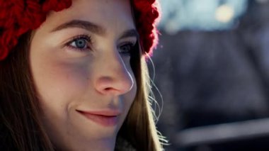 Kırmızı örgü şapkalı güzel kız. Soğuk hava ve komik kadın. Kışın sıcak buhar soluyan genç ve tapılası bir kadın. Kış kenti parkında hayal kuran genç bir kız. Yüksek kalite 4k görüntü