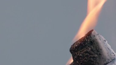 Gri arka planda izole edilmiş turuncu alev telli bir kulaklık, yanıklar, deformasyonlar, kıvrımlar ve beyaz bir kaplama ile erimiş bir kütleye dönüşür, kibrit çöpünün ateşiyle yok olur. Konsept