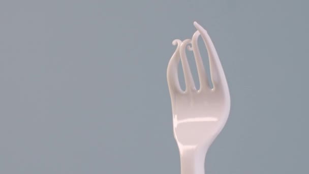 Een Ontstoken Witte Wegwerp Plastic Picknickvork Geïsoleerd Een Grijze Achtergrond — Stockvideo