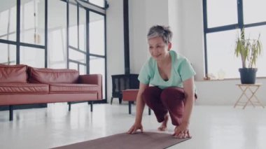 Yaşlı kadın evde yoga egzersizi yapıyor. Olgun kadınlar meditasyon yapar. Yüksek kalite 4k görüntü