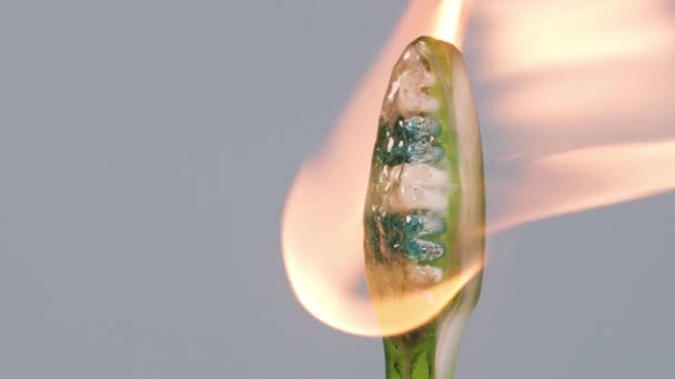Een Overspoeld Met Oranje Vlammen Heldere Driekleurige Plastic Tandenborstel Geïsoleerd — Stockvideo