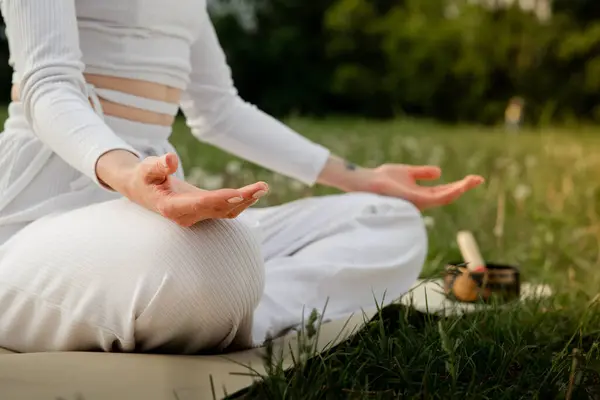 Meditasyon pozisyonunda avuçlarınızı açık tutun. Barış ve farkındalık kavramı. Bakıcı Lotus duruşunda oturan yoga koçu kız. Sakin sporcu kadın jest dengesi. Yüksek kalite fotoğraf