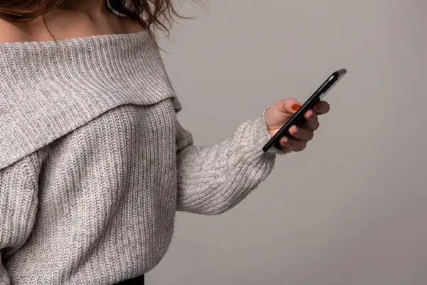 一个穿着毛衣拿着手机的女人的各种角度 图库图片