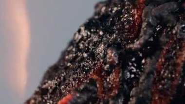 Ateşli bir yemek alevlerde yanar ve erir, dumanda kabarcıklar ve çıbanlar çıkarır, gri arka planda izole bir şekilde. Sıcak, yanmış, fazla pişmiş, yanmış ve bozulmuş bir tabak lava dönüştü. Kapat.