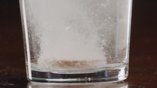 一杯水的底部躺着一颗白色的泡状药丸 它溶解并产生气泡 阿司匹林 防腐剂或解热药的广告 安全和负担得起的保健概念 — 图库视频影像