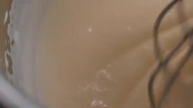 Bir tencere, un ve yumurtayı kasede karıştırıyor. Hamur yoğuruyorum. Pasta üretim sürecini kapat. Şekeri cam kasede yumurtalarla karıştıran karıştırıcı. Yumurta ve unla sütü karıştırıyorum. Yüksek kalite 4k