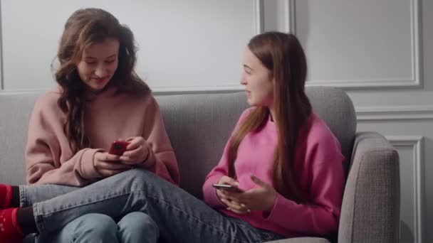 Duas Adolescentes Sorrindo Positivo Meninas Sentam Sofá Sala Uma Atmosfera — Vídeo de Stock