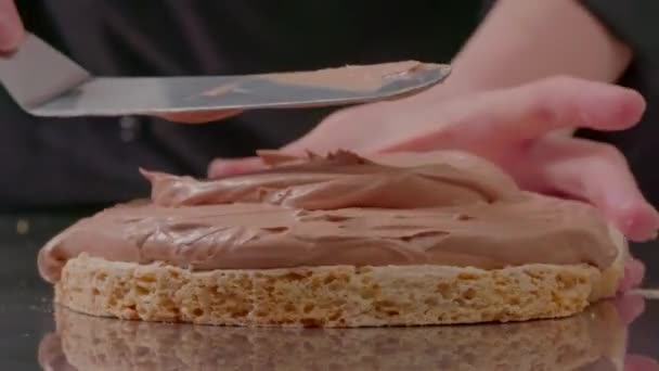 花生酱涂在蛋挞层上 关闭镜头釉层焦油 在蛋糕的侧面添加更多香草酱 厨师准备了第一层巧克力蛋糕 糕点厨师制作 — 图库视频影像