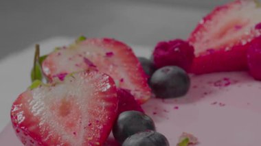 Meyveli pembe kremalı kek. Doğum günü tatili için tatlı, yeni pastane reklamı. Şekerleme kavramı. Şef mükemmel pembe pastaya fıstık ekliyor. Yüksek kalite 4k görüntü