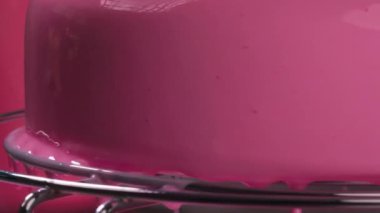 Parlak, pembe bir pasta servis ediyorum. El yapımı tatlı üretiminin reklamı. Doğum günü pastası konseptini bitirdim. Pembe parlak jöleli yumuşak pembe pasta. Yüksek kalite 4k görüntü