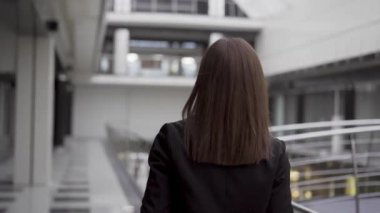 İş kadınının yeni modern ofisi tanıtırken çekilmiş dikiz görüntüsü. Yeni çalışma alanları keşfet. Uzay ofisi aç. Yürüyen başarılı iş kadınının arka plan görüntüsü. Merkez Ofisten Gezinti