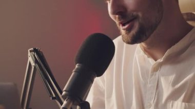 Kafkasyalı gülümseyen podcaster profesyonel mikrofona konuşuyor. Podcast sunucusu aboneler için iyi bir haber veriyor. Genç duygusal adam radyo yayıncısı sadece sohbet ediyor. Yüksek