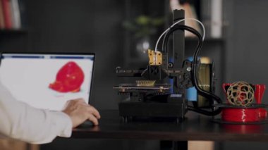 Bir grafik tasarımcı dizüstü bilgisayar kullanır ve insan kalbinin kırmızı renkte bir taslağını çizer, bir cihaz monitöründe tasvir edilir. 3D yazıcılarda organ nakli konsepti, gelecekteki...