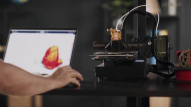 Bir grafik tasarımcı dizüstü bilgisayar kullanır ve insan kalbinin kırmızı renkte bir taslağını çizer, bir cihaz monitöründe tasvir edilir. 3D yazıcılarda organ nakli konsepti, gelecekteki...
