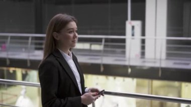 Başarılı, hırslı, genç bir bayan işyeri ofisinde akıllı telefonuyla yürüyor. Başvuru sahibi ile görüşmeye gidiyorum. İş kadını ofiste doğru toplantı odasını bulmak için akıllı telefonu kullanıyor.