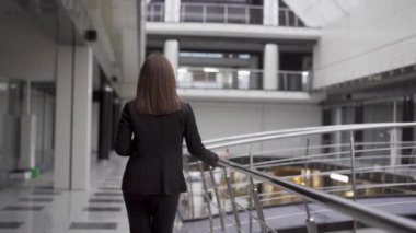 İş kadınının yeni modern ofisi tanıtırken çekilmiş dikiz görüntüsü. Yeni çalışma alanları keşfet. Uzay ofisi aç. Proje yöneticisi kadın resmi giyimli uluslararası şirketlerin ofisinde yürüyor. Yüksek