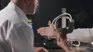 İki tıp mühendisi 3 boyutlu yazıcıda yapılan protez insan kafatasını tartışır. Tıbbi ve biyonik endüstride geleceğin teknolojisi. 3D yazıcı insanlar için protez yapıyor. Yüksek kalite 4k