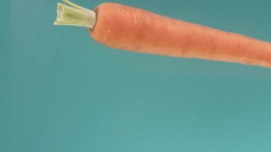 Havucun tek bir sebzesi turkuaz bir zemin üzerinde suyun yatay pozisyonuna düşer, ekseni etrafında bir girdap gibi döner, batar, dikey bir görüntüde yavaşlar. Sağlıklı olma kavramı