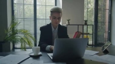Ofiste evrak okuyup laptopun yanında kahve içmekle meşgul bir kadın. Güzel iş kadını resmi takım elbise giyer plan listesini incelerken online toplantıya katılır. Raporlarla çalışan bir kız. Yüksek kalite