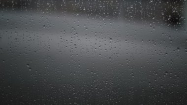 Yüksek çözünürlüklü bir pencerenin üzerindeki yağmur damlacıklarının yakın çekimi, hava ve ruh hali görselleri için mükemmel..