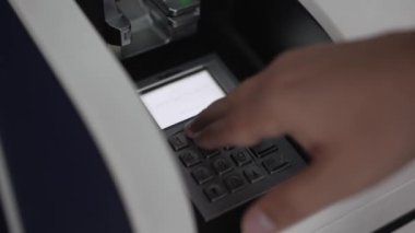 Güvenlik ve teknolojiyi vurgulayarak ATM 'nin tuş takımına şifreli giriş yapan bir kişinin yakın plan fotoğrafı.