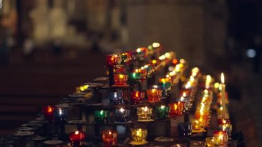 Renkli adak mumları huzurlu bir kilisede yanar, huzurlu ve sıcak bir atmosfer yaratır.