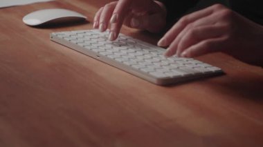 Kadın ellerine yakın durmak, iş yazışmalarının metnini yazmak. Bir iş kadını bilgisayar, kablosuz klavye kullanır, bilgi girmek veya aramak için fareyi kaydırır, bir işyerindeki bir masada çalışır