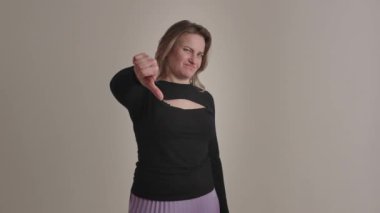 Bir kadın, arka planda birden fazla kare üzerinde başparmak ve nötr yüz ifadeleri sergiler..