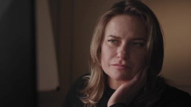 Genç, konsantre ve özenli Avrupalı ya da Amerikalı sarışın bir kadın bilgisayar ekranına bakar, iş ya da iş hakkında bilgi arar ve okur. İlgi ve düşüncenin göstergesi, bir el.