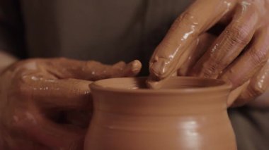 Çömlekçi bir adam oğluyla birlikte çalışır. Baba ve çocuk kilden bir sürahi şekillendirir. Ebeveyn sahibi erkek ellerini örter ve kendi toprak malzemelerini yapmasına yardım eder. Kalıtsal el işi ve yetenek aktarımı konsepti