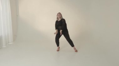 Yetenekli bir dansçı minimalist stüdyo ortamında etkileyici ve karmaşık hareketler sergiler.