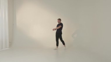 Yetenekli bir dansçı geniş, minimalist stüdyo alanında çağdaş hareketler sergiliyor.