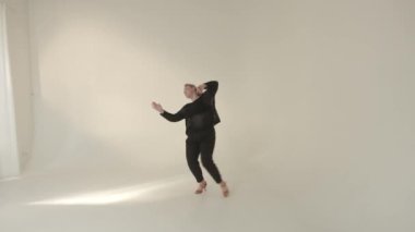 Yetenekli bir dansçı, sakin, minimalist stüdyo ortamında etkileyici ve dinamik hareketler sergiliyor.