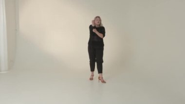 Şık bir kadın stüdyoda poz veriyor, modanın son modasını zarif ve stil sahibi bir şekilde sergiliyor.