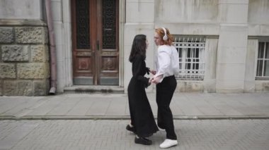 Bu video, hareketli bir şehrin kaldırımında neşeyle dans eden iki çifti gösteriyor. Bulaşıcı enerjiyle özel bir parti hazırlıyorlar.