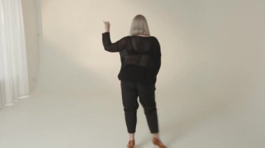 Modern minimalist stüdyo ortamında şık ve modaya uygun bir model zarif bir şekilde poz veriyor.