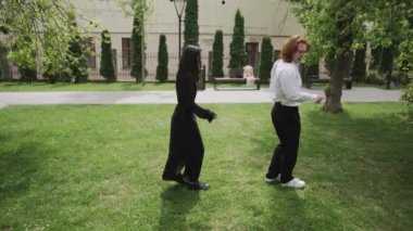 Canlı bir parkta, video çiftler ve arkadaşlar arasındaki neşeli anları gösteriyor. İki kadın sohbet eder, bir çift dans eder, diğeri el ele yürür, arkadaşlığı kutlar.