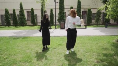 Parkta romantik bir sahnede bir adam ve bir kadın birlikte neşe içinde dans ederken geziniyor, gülüyor ve ilişkilerini derinleştiriyor.