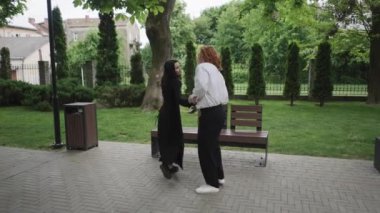 Canlı bir park, iki kadının dans etmesi, bir çiftin öpüşmesi, bir el sıkışması ve daha fazlasının yaşandığı iç açıcı bir bağ ve neşe anı sergiliyor.