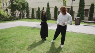 Romantik bir videoda bir adam ve bir kadın güzel bir parkta dans ediyor, doğa ile çevrili neşeli bir bağlantıyı paylaşıyor, aşkı somutlaştırıyor.