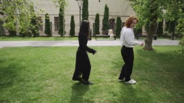 Canlı bir parkta, video çiftler ve arkadaşlar arasındaki neşeli anları gösteriyor. İki kadın sohbet eder, bir çift dans eder, diğeri el ele yürür, arkadaşlığı kutlar.