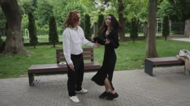 Yürek ısıtan bir video parkta bir erkek ve bir kadın kucaklaşırken, iki kadın neşeyle dans ediyor, ilişkileri kutluyorlar.